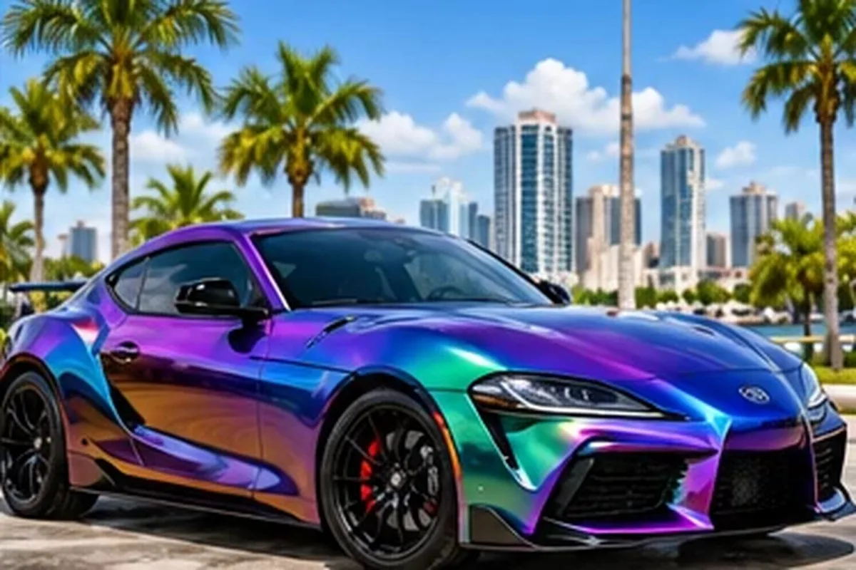 Color-shift purple and teal wrapped sport sedan against the San Diego skyline
